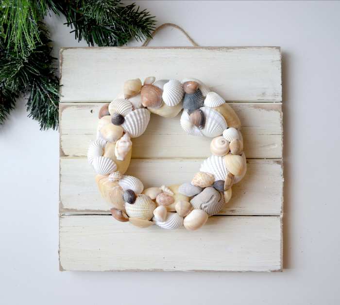 Coastal seashell wreath hanging on wall